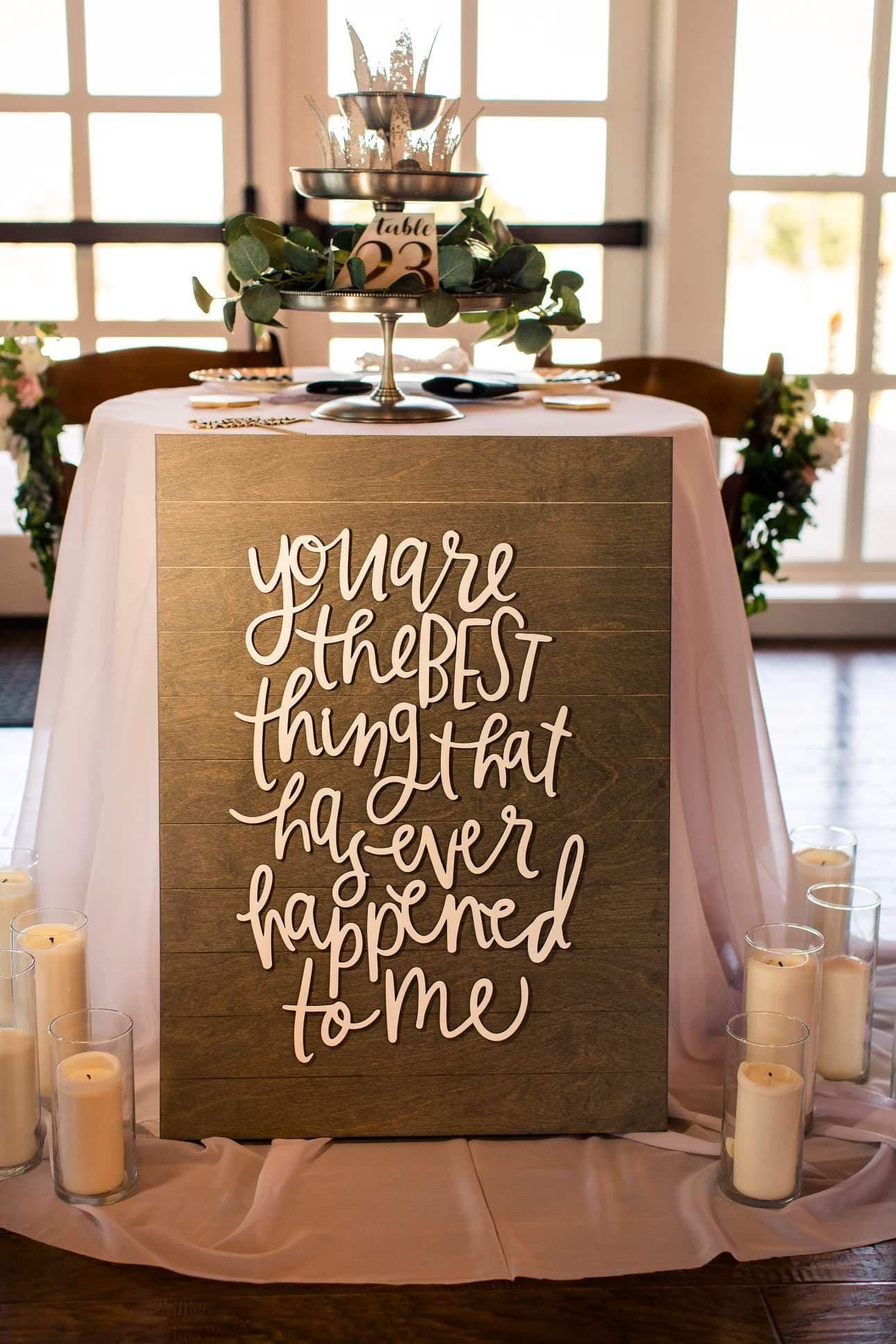 a decorative table setting with a sign that says you are the best thing that has ever happened to me surrounded by candles